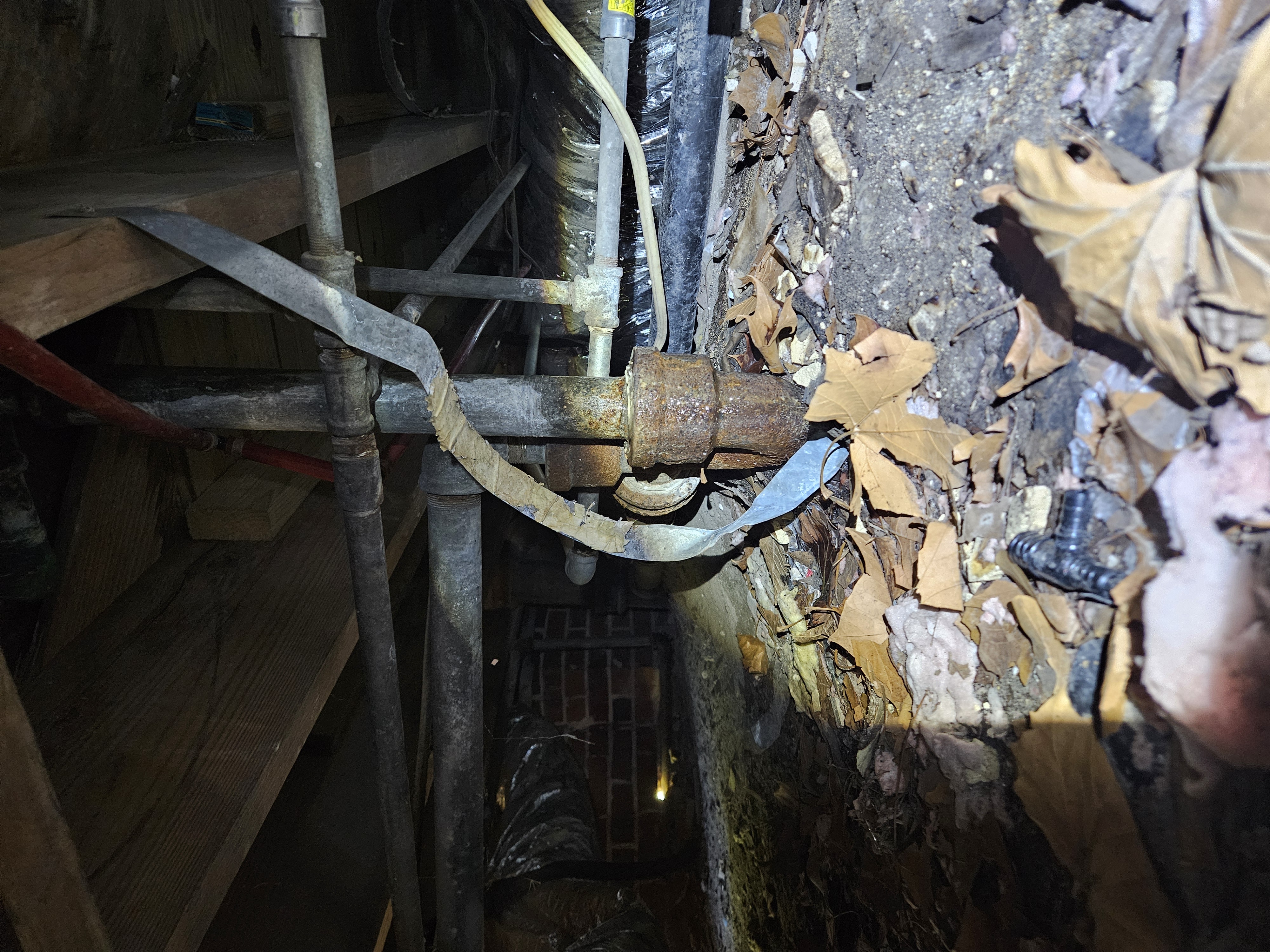 Active sewer pipe leak discovered in crawl space — sewage draining directly onto the ground beneath the home.
